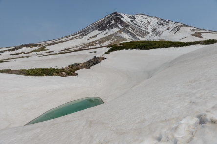 One of the small crater lakes begins to defrost on Asahidake, a volcano in Daisetsuzan National Park.